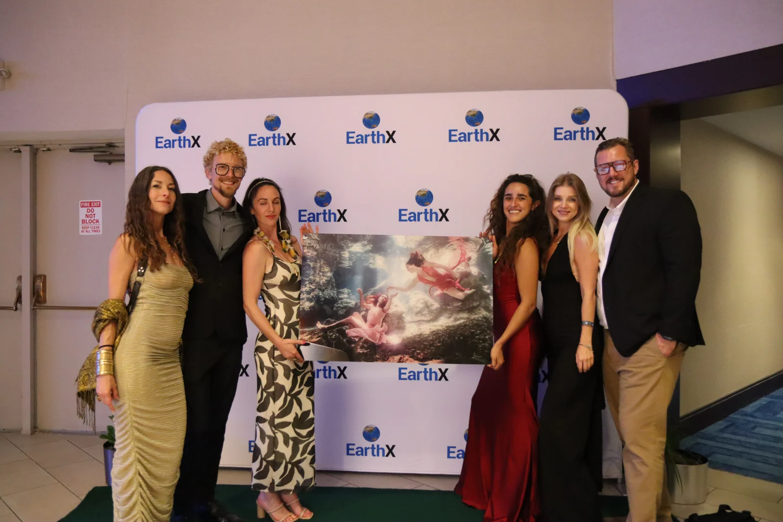 Steph Ferrera at EarthX holding the framed painting The Birth of Eden, the piece that would later be carried to the Moon.