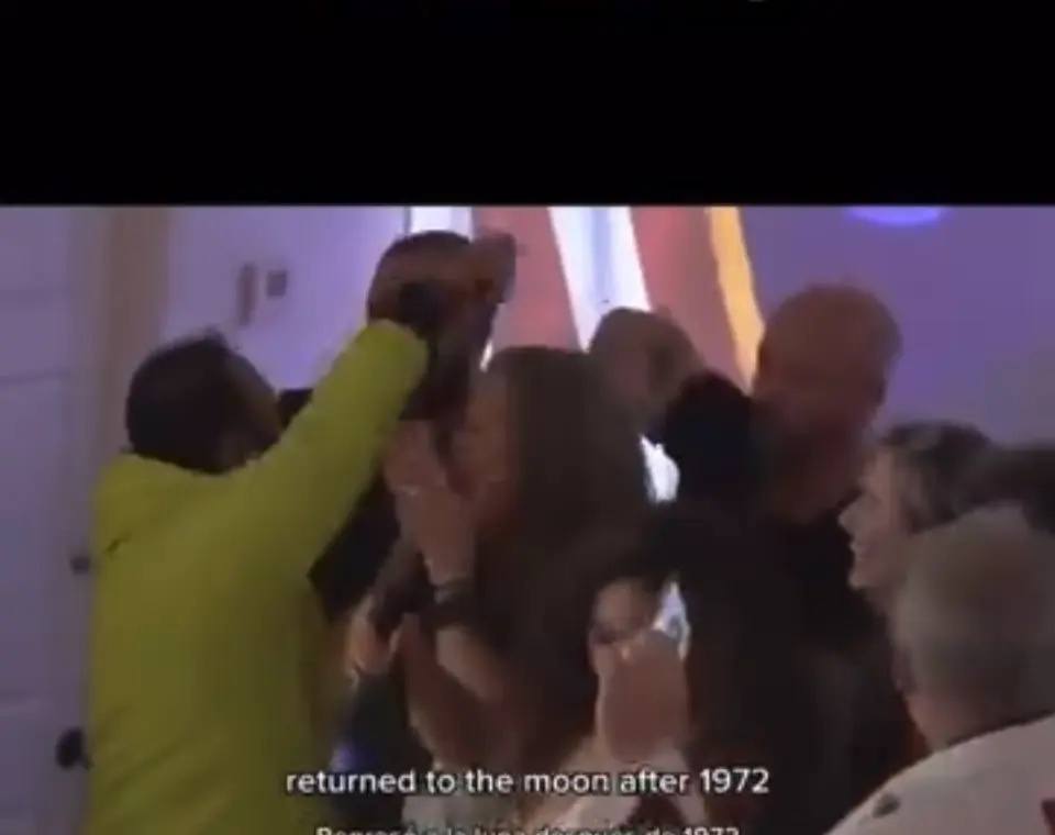 People holding each other in a control room as the landing is confirmed.