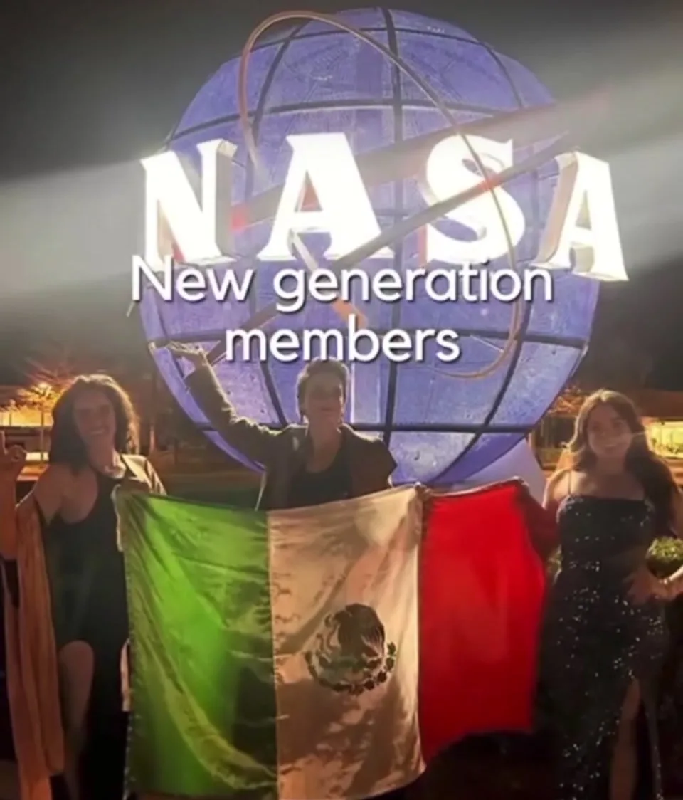 Under the NASA globe reading New Generation Members, a group holding the Mexican flag at night.