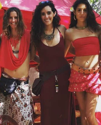 Steph outside the Red Tent in the jungle, in a wine dress with a layered necklace.